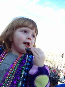 My baby girl at the Mardi Gras parade, scarfing down a moon pie.